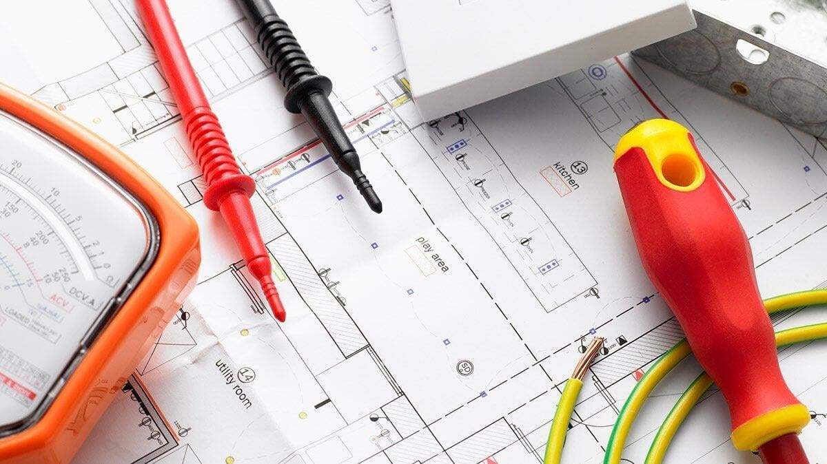Electrical test leads, tools and wiring on a building plan