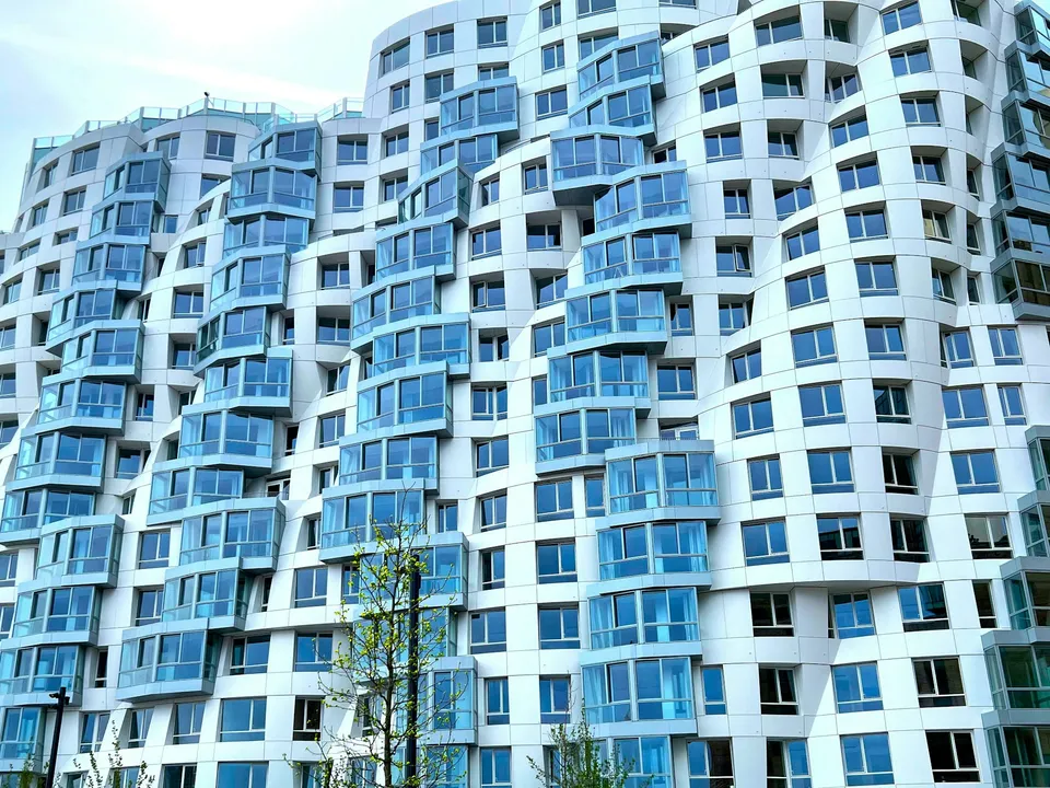 White residential buildings with blue glazing and curved balconies in London
